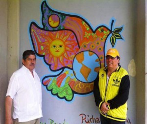 Los doctores Omar Pérez Díaz y Pascual Mora junto al mural elaborado por los estudiantes del Servicio Comunitario